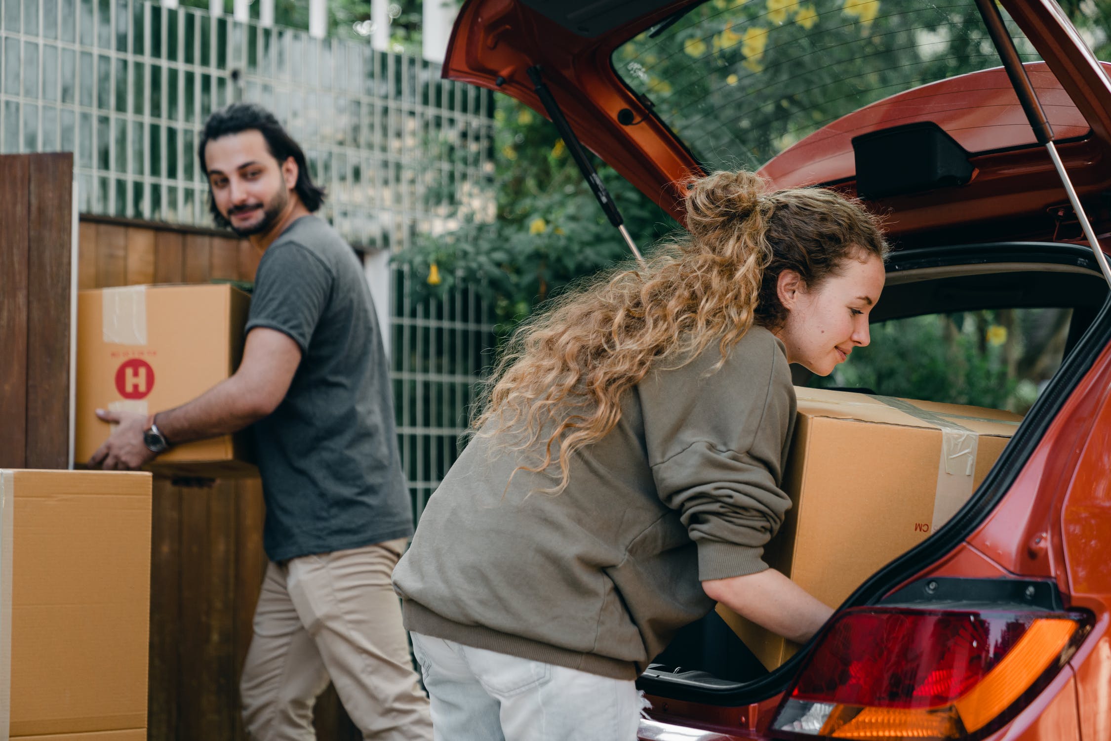 person helping load car with boxes